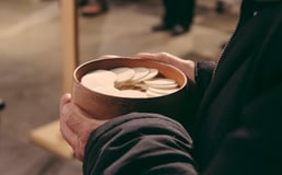 hands holding a ciborium of hosts