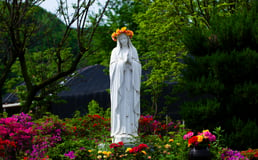 Statue of Mary in garden with flower crown