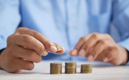 a hand puts coins in a stack