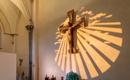 crucifix on wall in sunlight