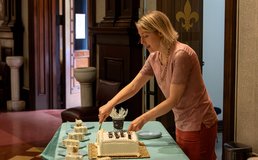 Hospitality Committee member cutting cake