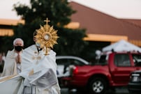 a priest holds a monstrance