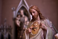 a statue of Jesus Christ points to his Sacred Heart