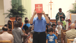 man holding bible with children from mustard seed group