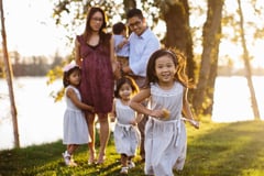 parents and kids posing near water at sunset