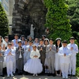 Children posing for photo after first communion dressed in white