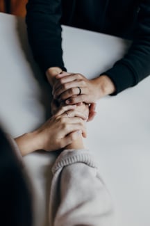 close up of two people holding hands in support