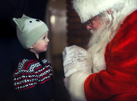 a small child smiles at Santa Claus