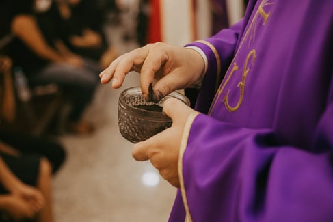 close up of a priest getting ready to distribute ashes