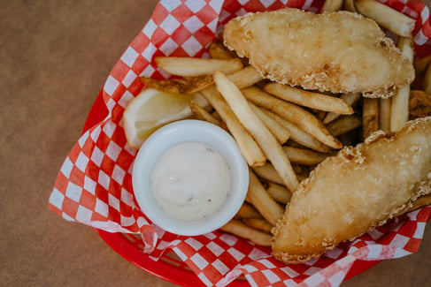 a basket of fried fish, french fries, and tartar sauce